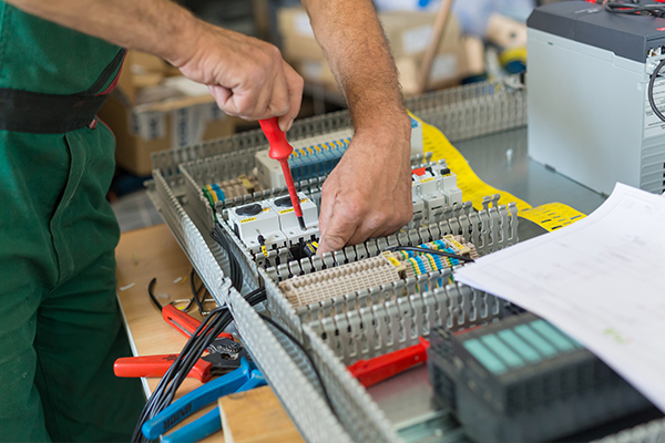 An image of an electrician working at a circuit board
